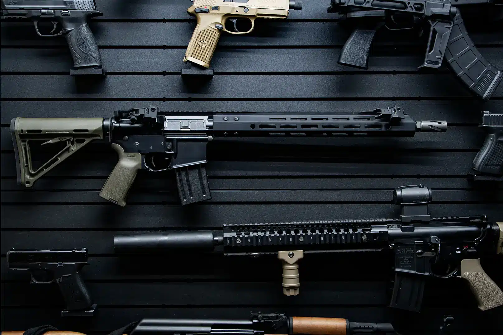 ModWall 9 Gun Combo Pack A detailed view of several firearms, including AR-15 rifles and handguns, mounted on a black ModWall panel to demonstrate the visual pleasure of the ModWall 9 Gun Combo Pack.