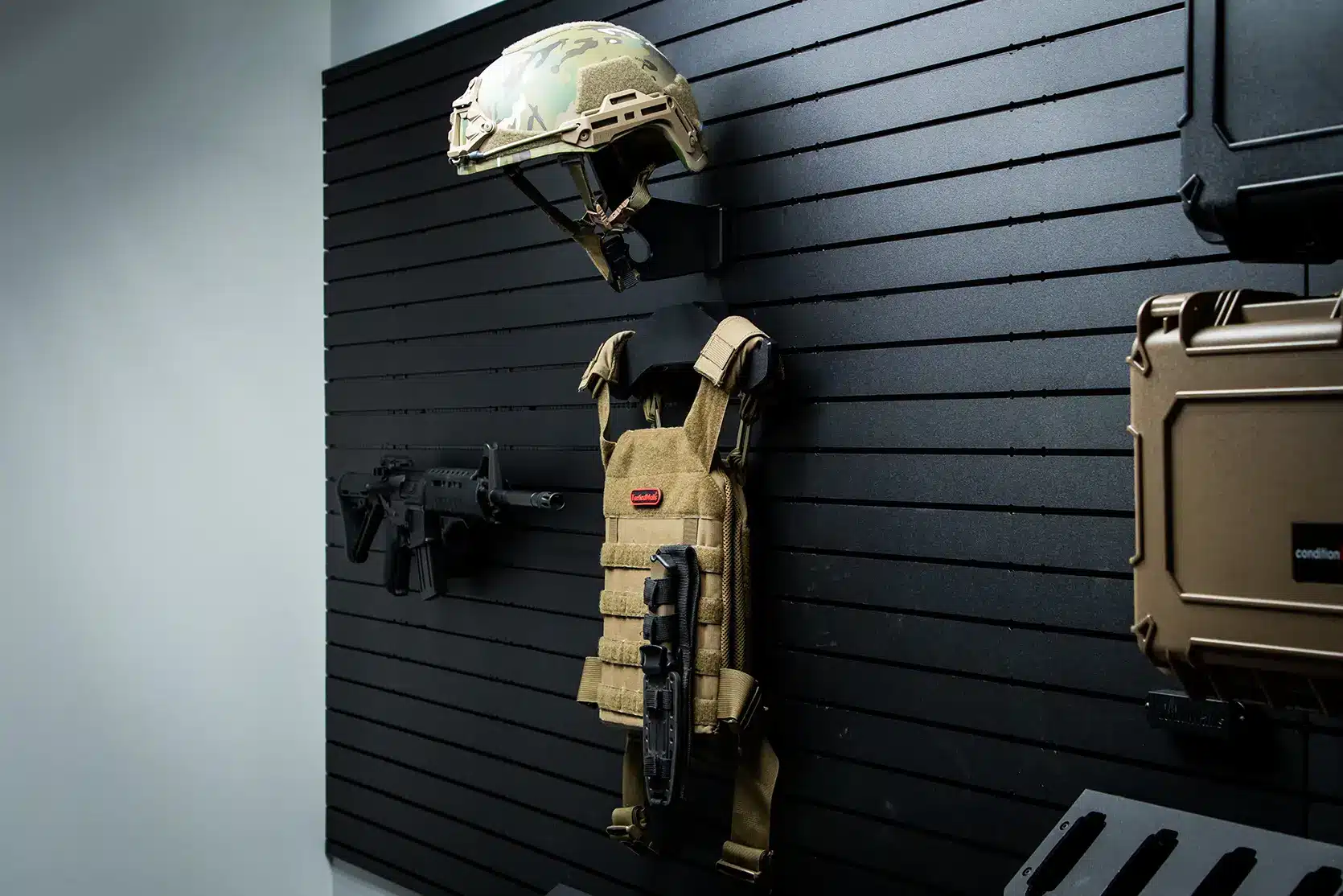 Wall mounted helmet hanger on ModWall panel beside other gear.