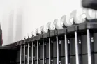 A closeup of an organized set of hand wrenches mounted on a black, wall panel.