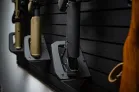 A closeup picture of the bottom shelf piece of the long gun wall mount on a black panel.