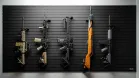 5 different-sized rifles mounted vertically on a black ModWall panel, showcasing the mount's flexibility in storing various long guns.