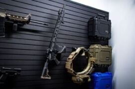 A long gun mounted on a ModWall panel along with a duty belt holder and three condition1 cases, showcasing a seamless tactical setup.