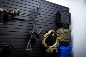 A long gun mounted on a ModWall panel along with a duty belt holder and three condition1 cases, showcasing a seamless tactical setup.