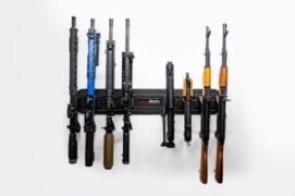 Vertical rifle storage setup holding rifles by the magwell on a narrow wall panel