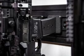 Modwall vertical rifle hangers holding an AR-style rifle by the mag well