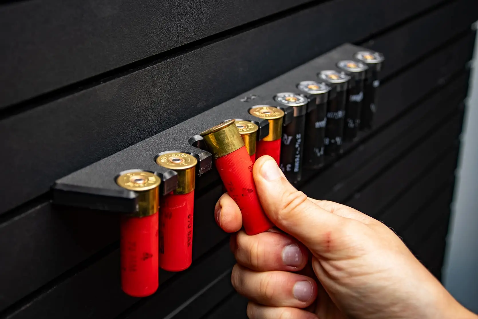 ModWall 9 Gun Combo Pack A person's hand grabbing a red shotgun shell from the ModWall shell holder attachment.