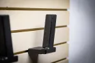 ModWall Pistol Hangers An empty pistol hanger mounted on a tan gun wall display system, featuring double-stack mag well support.