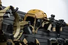 Yellowstone Marshals Arsenal Package Tan ballistic helmet and tactical rifles mounted on the black slatwall panels.