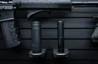 ModWall Suppressor Holder Two black silencers of different sizes stored on wall-mounted pegs.