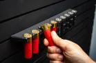 ModWall 9 Gun Combo Pack A person's hand grabbing a red shotgun shell from the ModWall shell holder attachment.