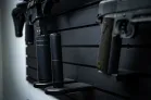 ModWall Suppressor Holder A close, side-angle view of two black suppressors of different sizes stored on the ModWall Suppressor Holders