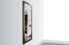 1450 Framed Concealment Mirror A full-length rectangular mirror with a brown (Walnut color), textured wood frame mounted vertically on a light gray wall.