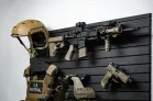 Yellowstone Marshals Gun Wall Package Close-up of the upper section of the ModWall Yellowstone Marshals Gun Wall Package highlighting a mounted tactical rifle, handgun, and tan combat helmet.