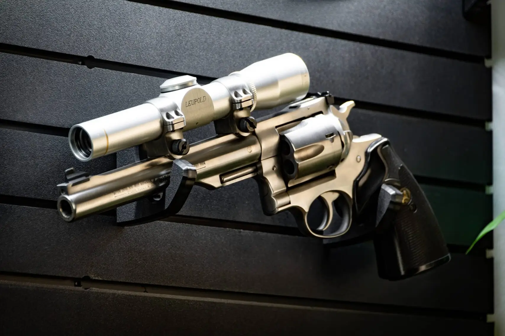 ModWall Handgun Rack A revolver with an optic resting on a wall mounted handgun rack, showcasing compatibility with handgun optics and other attached accessories.
