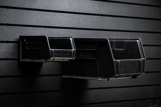 Two black Uline bins mounted on a wall panel showcasing flexible bin sizing.
