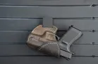 ModWall Holster Hanger A pistol in its holster hung upside down against the ModWall panel, showcasing flexible mounting options.