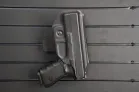 ModWall Holster Hanger A handgun stored vertically in its casing against a panel.