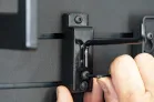 ModWall Magnetic Weapon Lock The extra button screw on the accessory hook being tightened to secure against the ModWall panel.
