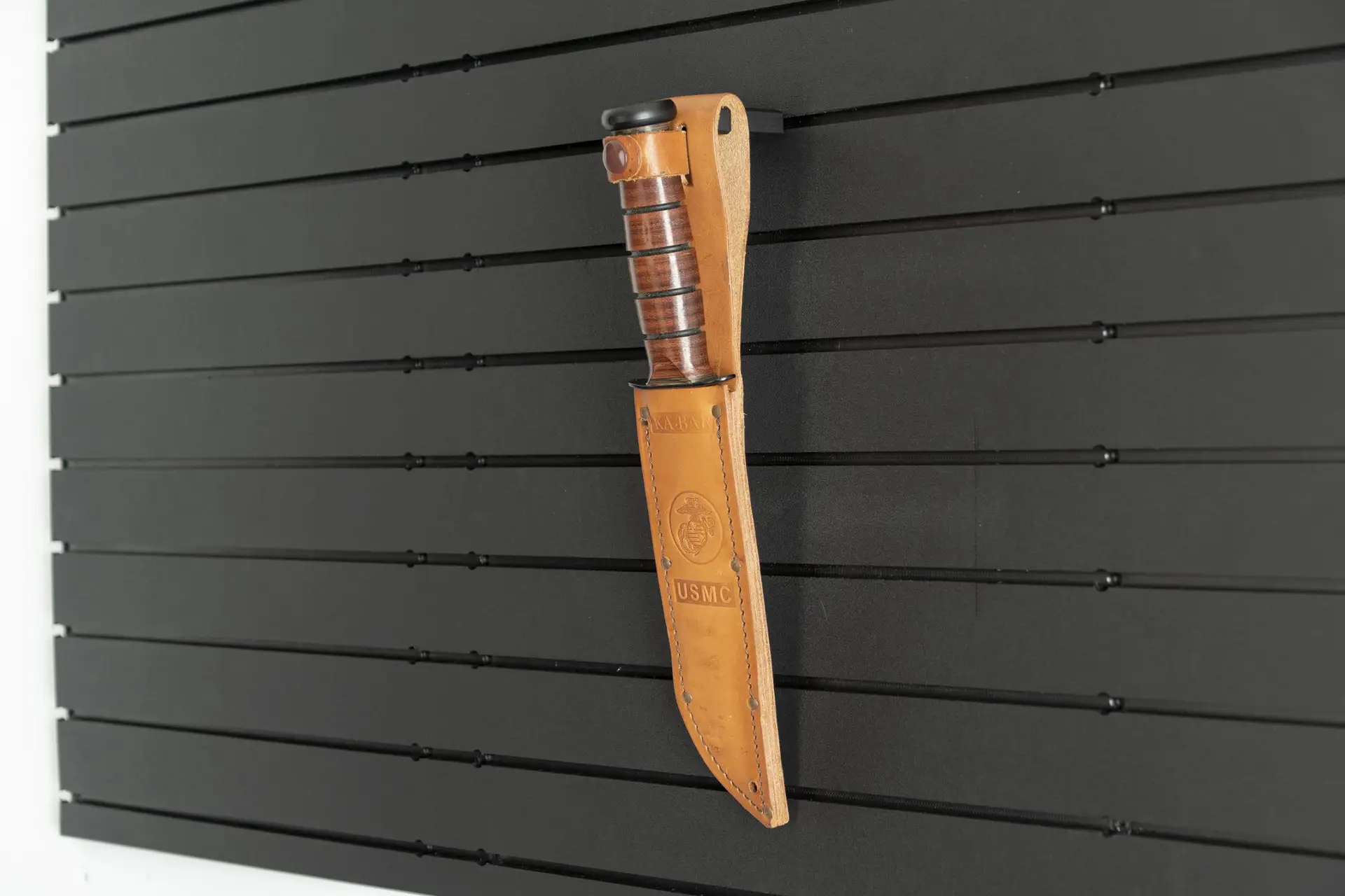 ModWall Tactical Belt Mount A tan knife sheath stored on a ModWall panel using a black, slim holder.
