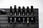 ModWall Compact 21 Gun Package A top-down view of six handguns secured in a vertical rack on a black modular wall panel.