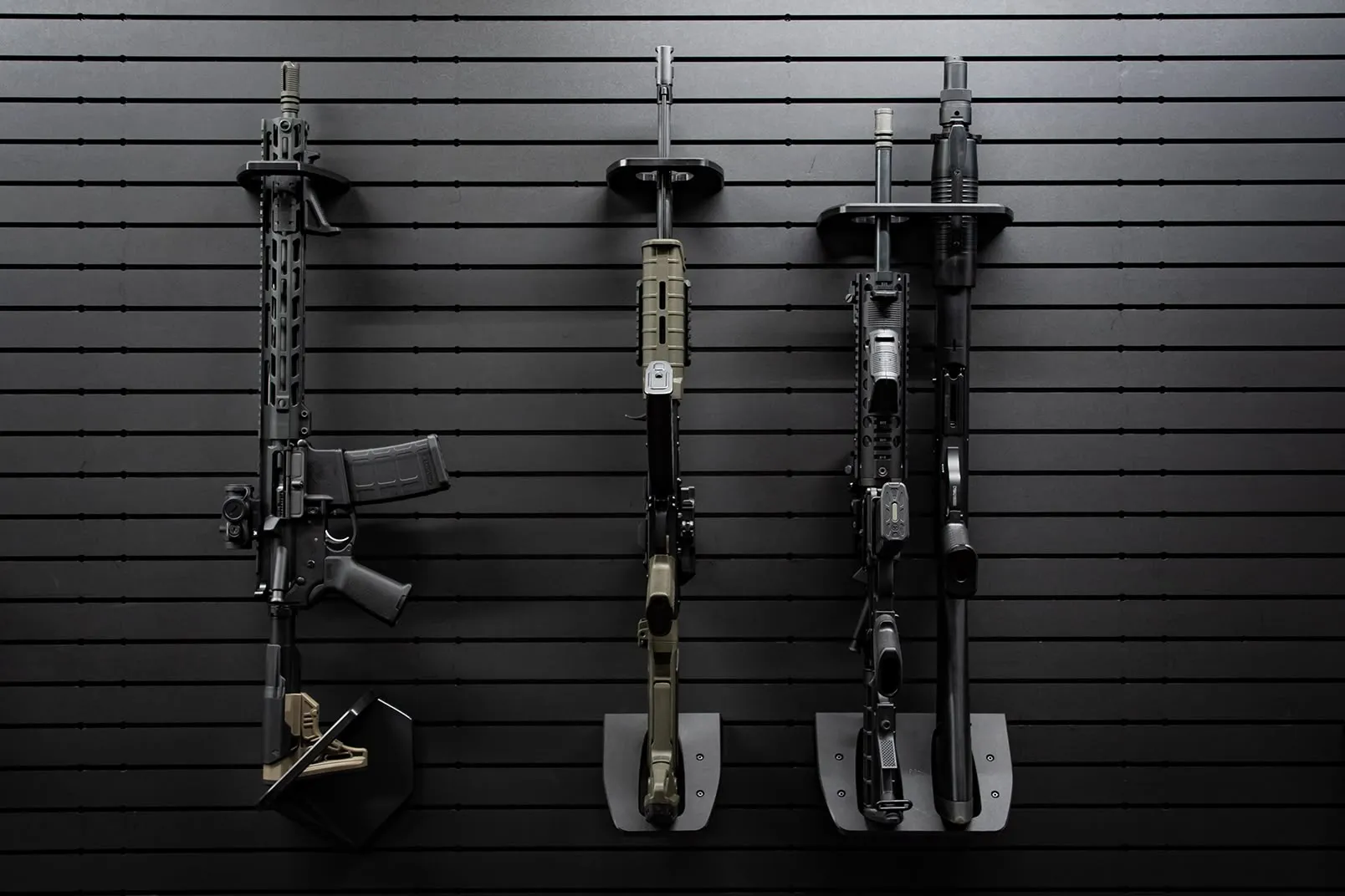 ModWall Vertical Two Rifle Rack Four different firearms are arranged side-by-side on a black modular panel using different accessory variations.