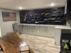 ModWall Panels (48″Wx22″H) A large-scale basement gun room featuring the pre-built ModWall Patriot Pack used to horizontally display an extensive collection of rifles and handguns.