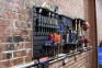 ModWall Project Package ModWall Project Package mounted on a brick wall displaying screwdrivers, wrenches, air tools, power drills, and storage bins on a black HDPE panel for modular garage tool storage.