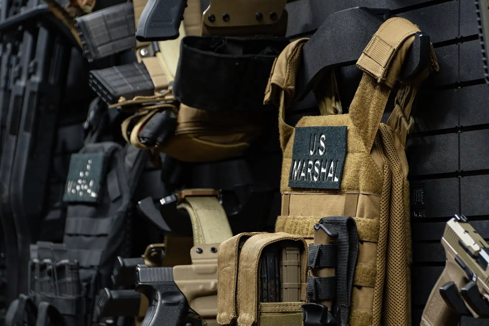 Yellowstone Marshals Arsenal Package Detailed view of tactical duty gear and plate carrier mounts on the gun wall.
