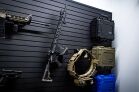 ModWall Case Adapters A long gun mounted on a ModWall panel along with a duty belt holder and three condition1 cases, showcasing a seamless tactical setup.