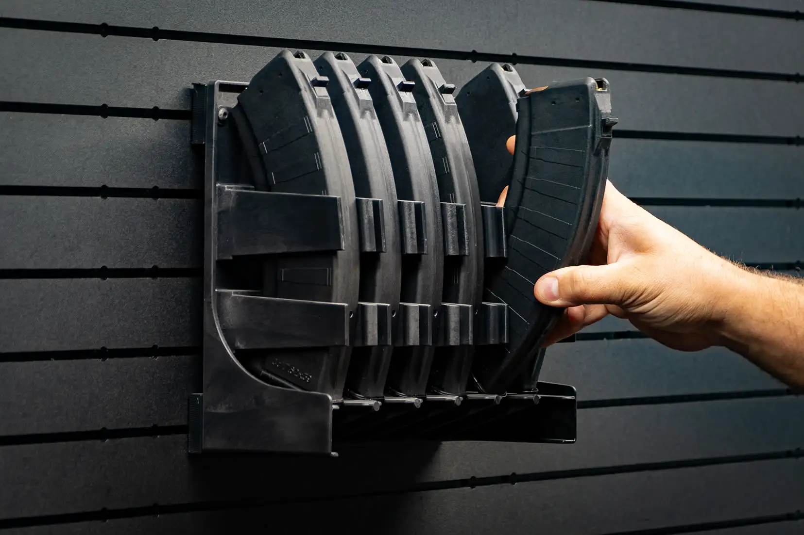 ModWall Mag Racks A person accessing an AK-47 magazine with ease from the wall mounted gun magazine rack.