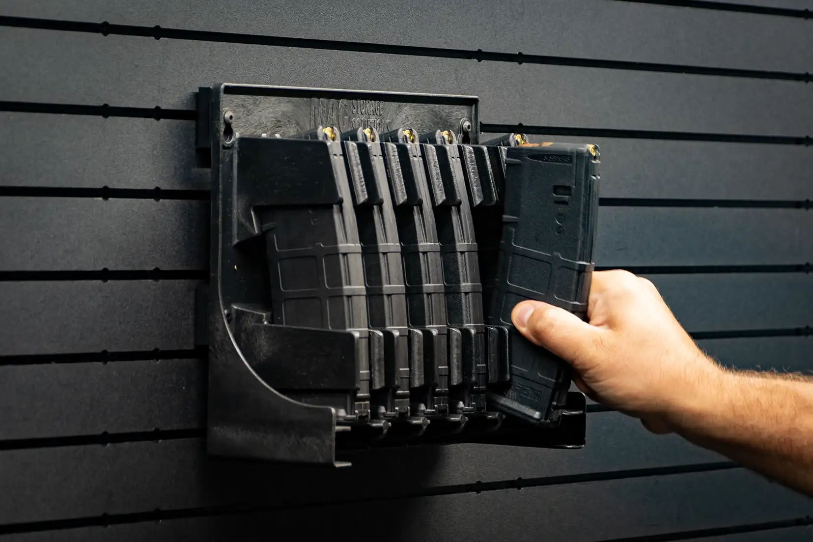 ModWall Mag Racks A person accessing an AR-15 magazine with ease from the wall mounted gun magazine rack.