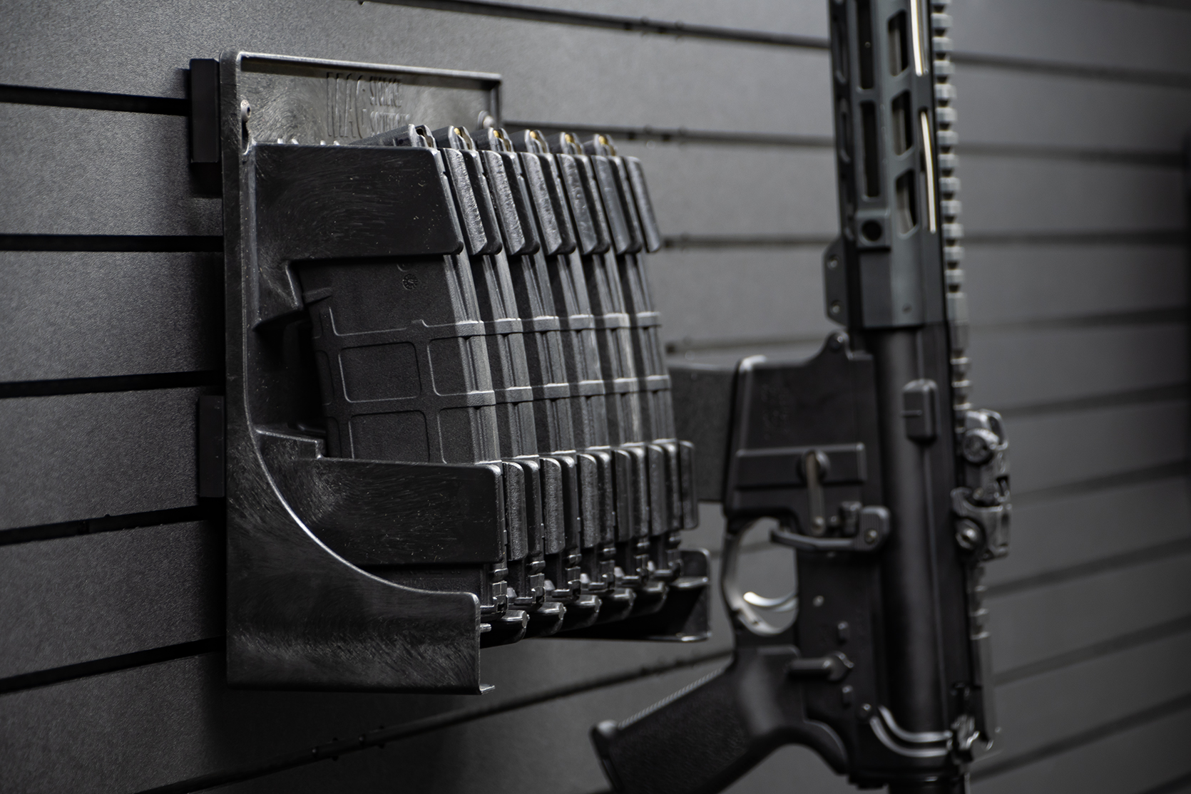 ModWall Mag Racks A rack of AR-15 magazines mounted on the wall alongside an AR-15 rifle hung vertically.