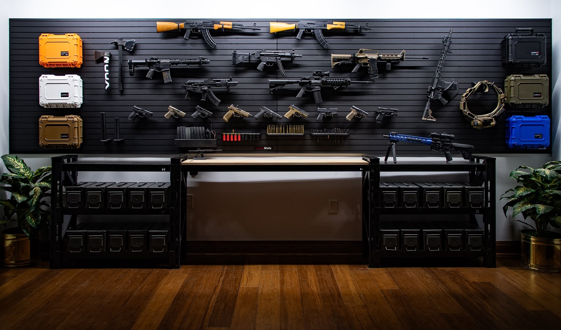A wall-spanning, modular gun room setup featuring hand guns, long guns, ammo racks, case adapters, and other tactical accessories.