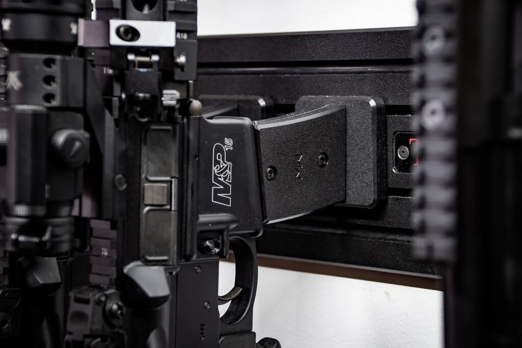 Modwall vertical rifle hangers holding an AR-style rifle by the mag well